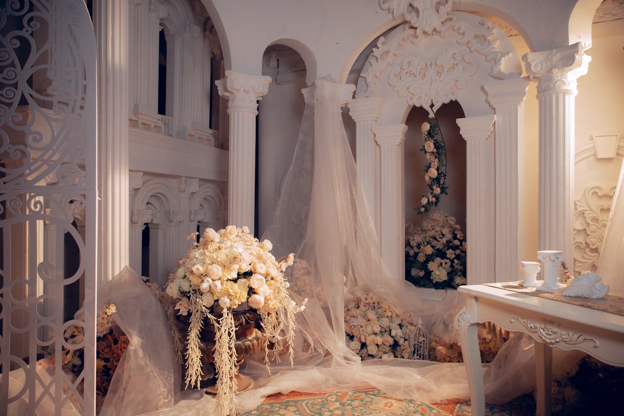 about-01 Luxurious wedding room with ornate columns and elegant white floral decorations.
